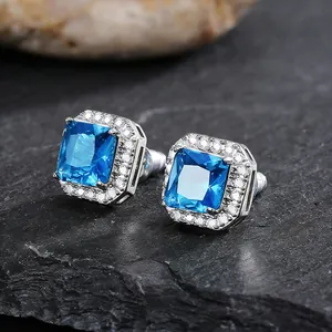 Close-up view of elegant square-cut blue zircon stud earrings with a halo diamond setting