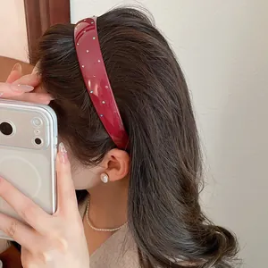 Vintage wide-brimmed burgundy acrylic headband with colorful rhinestones worn on hair