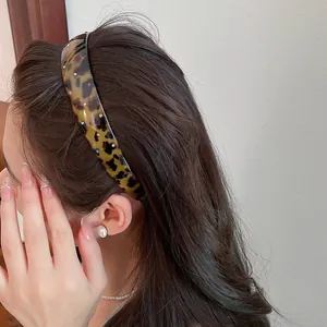 Close-up detail of leopard print acrylic headband with colorful rhinestones on hair