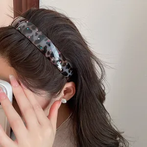Close-up of vintage leopard print acrylic headband with colorful rhinestones