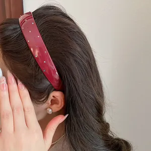 Macro view of vintage burgundy acrylic headband featuring sparkling colorful rhinestones