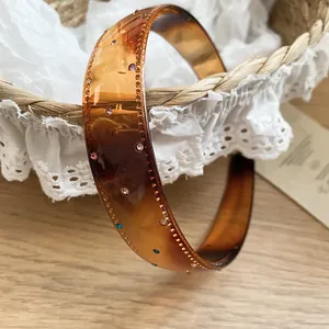 Detailed close-up of a vintage tortoiseshell acrylic headband with colorful rhinestones