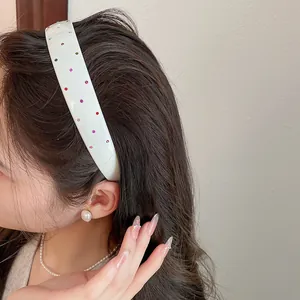 Close-up of white acrylic headband with colorful rhinestones on a female model