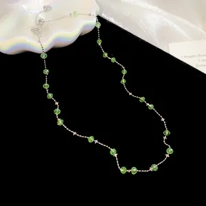 Detailansicht der grünen Kristallperlen an einer zarten silbernen Halskette