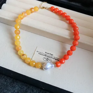 Macro view of colorful dopamine acrylic beaded necklace with a central baroque pearl detail