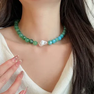 Detail shot of a colorful beaded necklace with a central baroque pearl on a model.