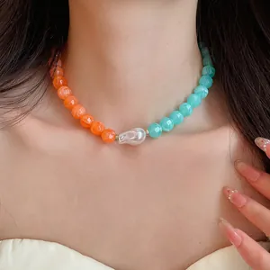 Close-up of a vibrant two-tone acrylic beaded choker with a central baroque pearl.