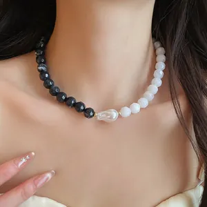 Close-up of a chic black and white acrylic beaded necklace with a baroque pearl detail.