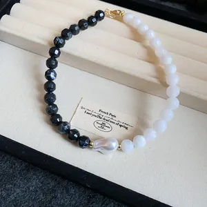 Handcrafted necklace featuring black and white faceted beads and a unique baroque pearl