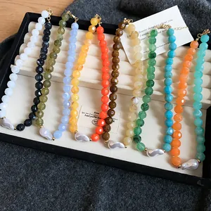 Colorful dopamine acrylic bead necklaces with pearl pendants displayed in a tray.