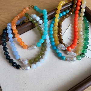 Close-up detail of colorful dopamine acrylic bead necklaces with baroque pearls on tray