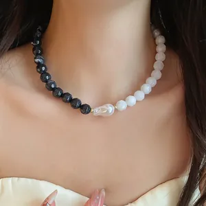 Close-up of a stylish black and white faceted beaded necklace featuring a central baroque pearl