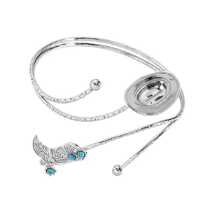 Gedetailleerd overzicht van een zilveren cowboy-armring met turquoise laarzen en hoedmotief