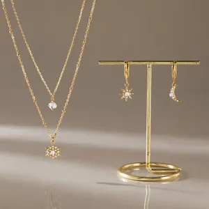 Detailaufnahme von goldener Mondstein-Halskette und asymmetrischen Ohrringen im Set