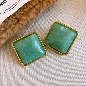 Orecchini retrò quadrati in acrilico verde smeraldo con bordi dorati su tela rustica