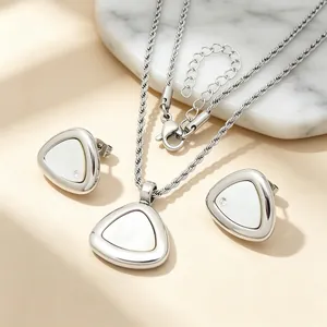 Detailansicht eines silbernen Edelstahlschmucksets mit Dreieck-Muschel-Anhängern.