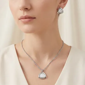 Modell trägt elegantes Set aus Edelstahldreiecks-Muschelhalskette und passenden Ohrringen