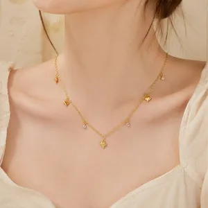 Detail van een gouden roestvrijstalen ketting met hartjes en zirkonia-steentjes.