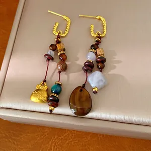 Detailed view of handmade ethnic earrings with wooden beads and resin pendants
