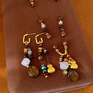 Detail of ethnic retro jewelry set with wood beads and resin water drop pendant