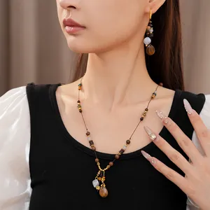 Detailed close-up of ethnic vintage wooden beaded necklace and earring set worn by a model
