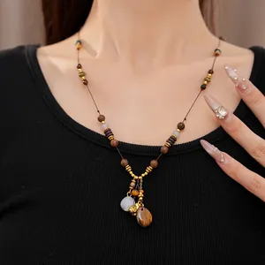 Detail of ethnic retro wood beaded necklace with resin teardrop and lucky bag pendants