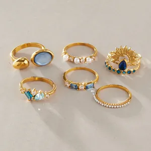 Detailed close-up of golden stainless steel rings with blue natural stones and pearls