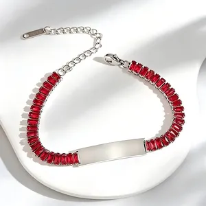 Detailed view of a stainless steel bracelet with red baguette-cut zircons and engraving plate.