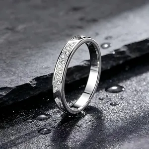 Nahaufnahme eines CNC-gravierten Edelstahlrings mit Kristallen auf Steinoberfläche