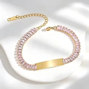 Detail shot of gold stainless steel bracelet with pink cubic zirconia and engravable plate.