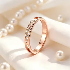 Detailaufnahme eines roségoldenen Edelstahlrings mit geometrischen Mustern und Kristallen