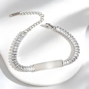 Detail of silver stainless steel bracelet with square zircons and engravable plate