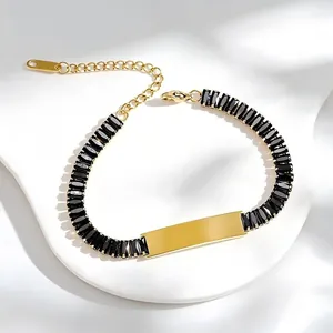 Detail of gold stainless steel bracelet with black zircon stones and engravable bar