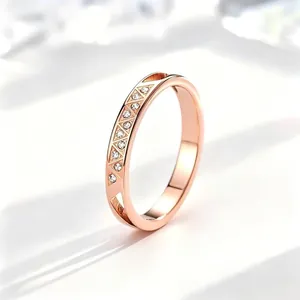 Nahaufnahme eines roségoldenen Edelstahlrings mit CNC-Gravur und eingesetzten Kristallen.