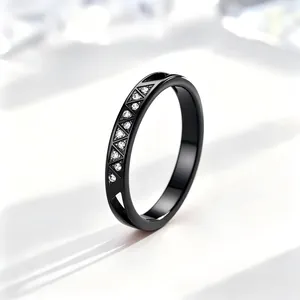 Nahaufnahme eines schwarzen Edelstahlrings mit CNC-gravierten Dreiecken und Kristallen