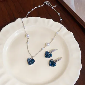 Parure de bijoux vintage avec collier et boucles d'oreilles cœur bleu sur plat