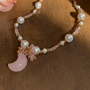 Sweet Korean style pearl necklace featuring a pink moon pendant and floral crystals.