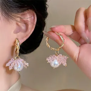 Close-up detail of elegant gold-toned hoop earrings with pink crystal beads and pearls