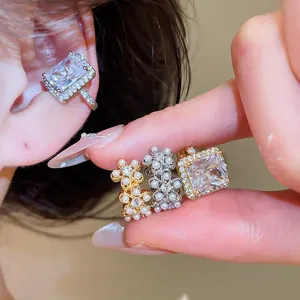 Gros plan détaillé des boucles d'oreilles ear cuff en zircon et perles dorées 18k