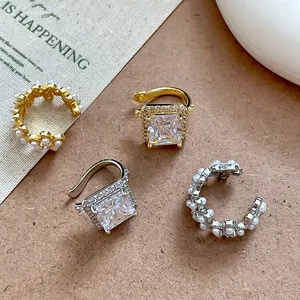 Détail de boucles d'oreilles plaquées or 18 carats avec zircon et fleurs de perles