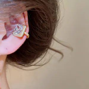 Gros plan d'un luxueux earcuff en plaqué or 18 carats avec zircon cubique taille émeraude.