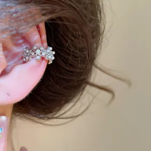 Gros plan élégant d'un ear cuff vintage fleur et perle avec zircons, sans perçage pour femme