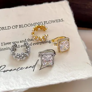 Gros plan sur des ear cuffs en perles et zircons plaqués or 18 carats au style rétro