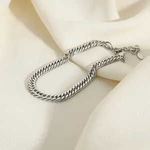 Elegant silver stainless steel Cuban link chain bracelet for women on soft silk background