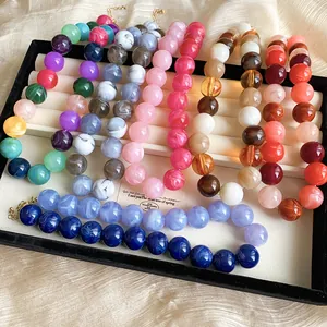 Variety of colorful acrylic beaded necklaces in a professional jewelry display tray