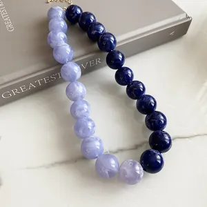 Detailed macro view of a two-tone acrylic beaded necklace in lavender and navy blue tones