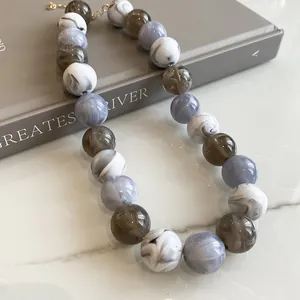 Detailed macro view of marble pattern acrylic beaded necklace in gray and white