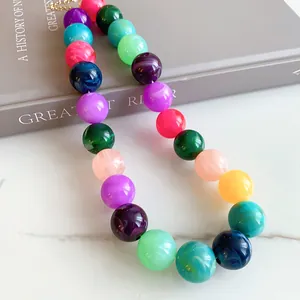 Close-up of vibrant dopamine style acrylic beaded necklace on marble background
