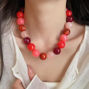 Close-up of vibrant dopamine red and pink acrylic bead choker necklace on model's neck