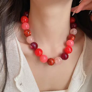 Close-up of a colorful dopamine style acrylic beaded necklace on a model's neck.